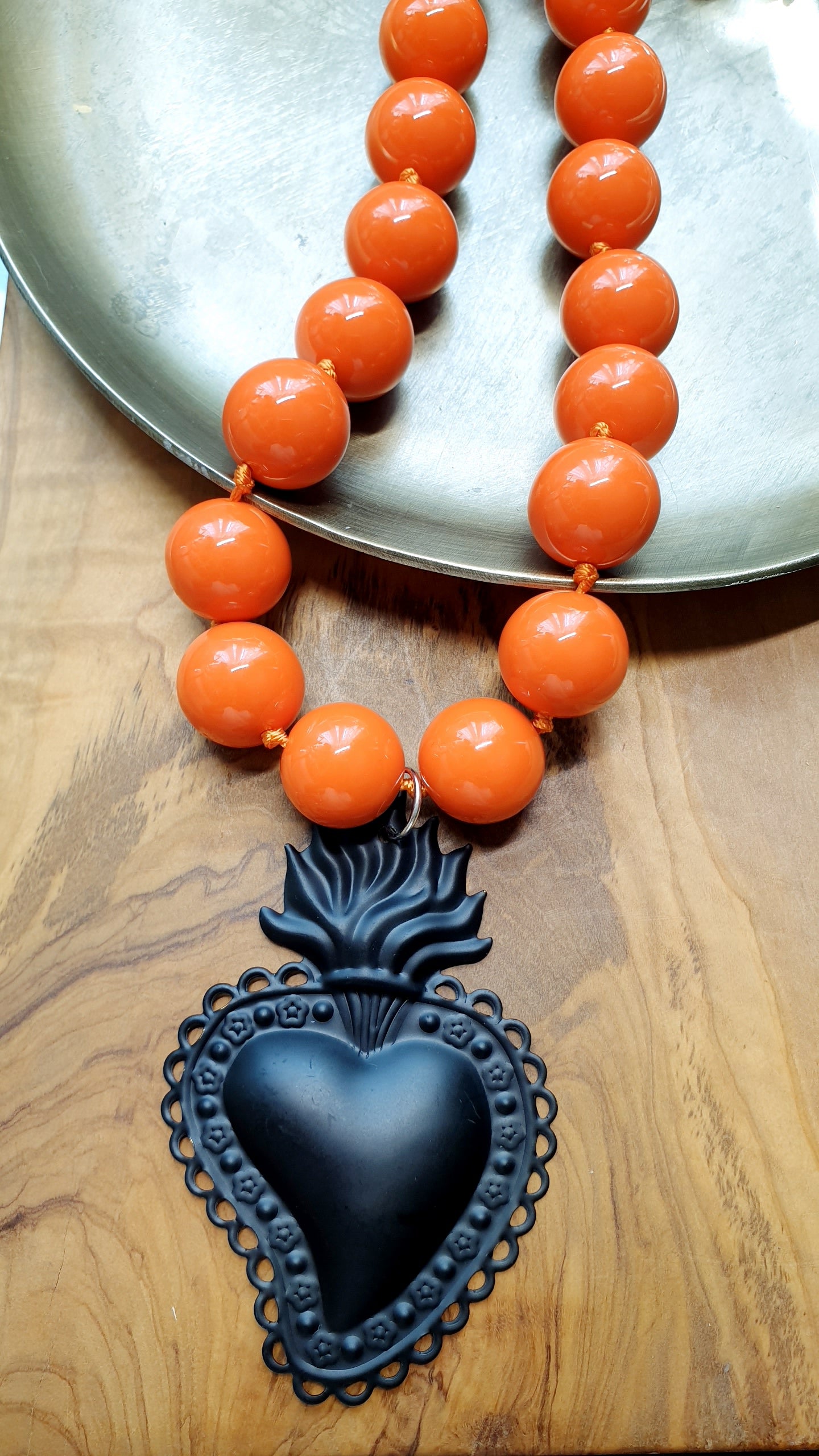 Girocollo in resina arancio con cuore sacro in metallo