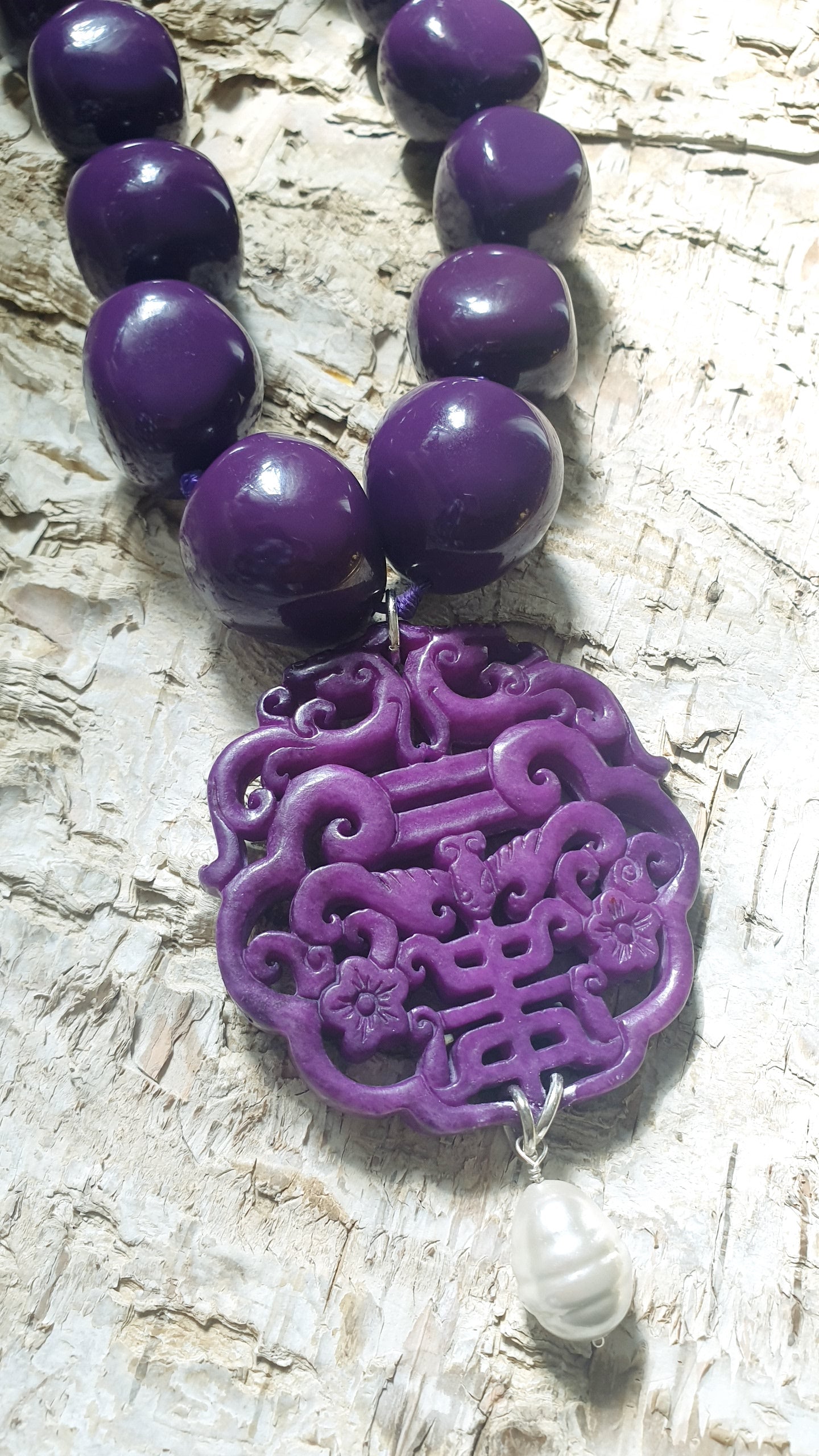 Collana in resina con giada intagliata e perla.