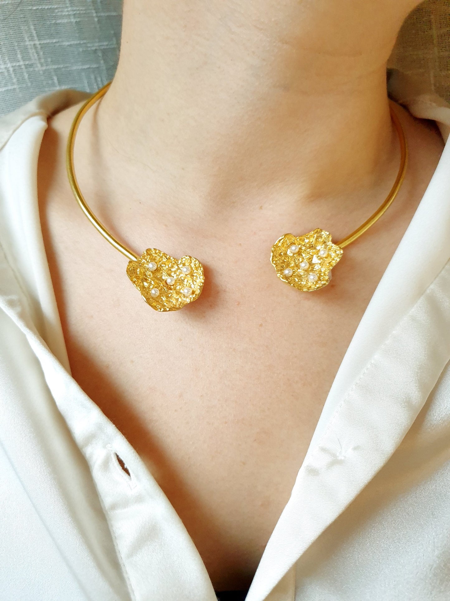 Halsband aus Messing mit Motiven und Perlen.