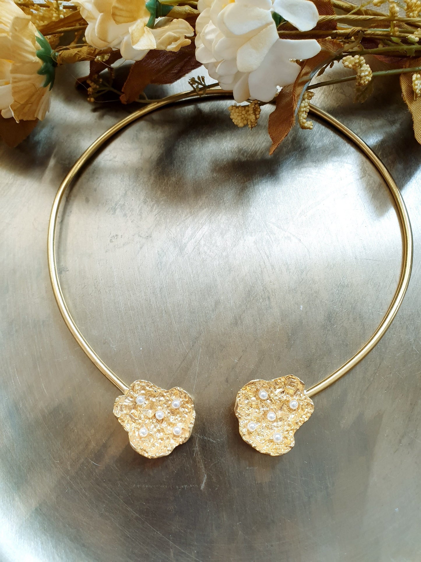 Halsband aus Messing mit Motiven und Perlen.