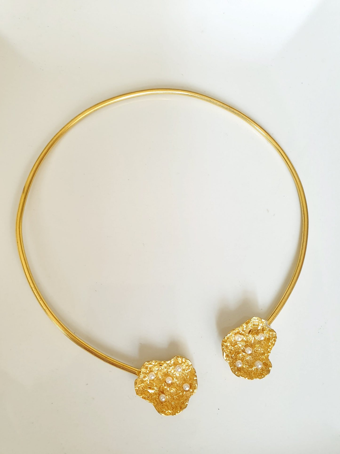 Halsband aus Messing mit Motiven und Perlen.