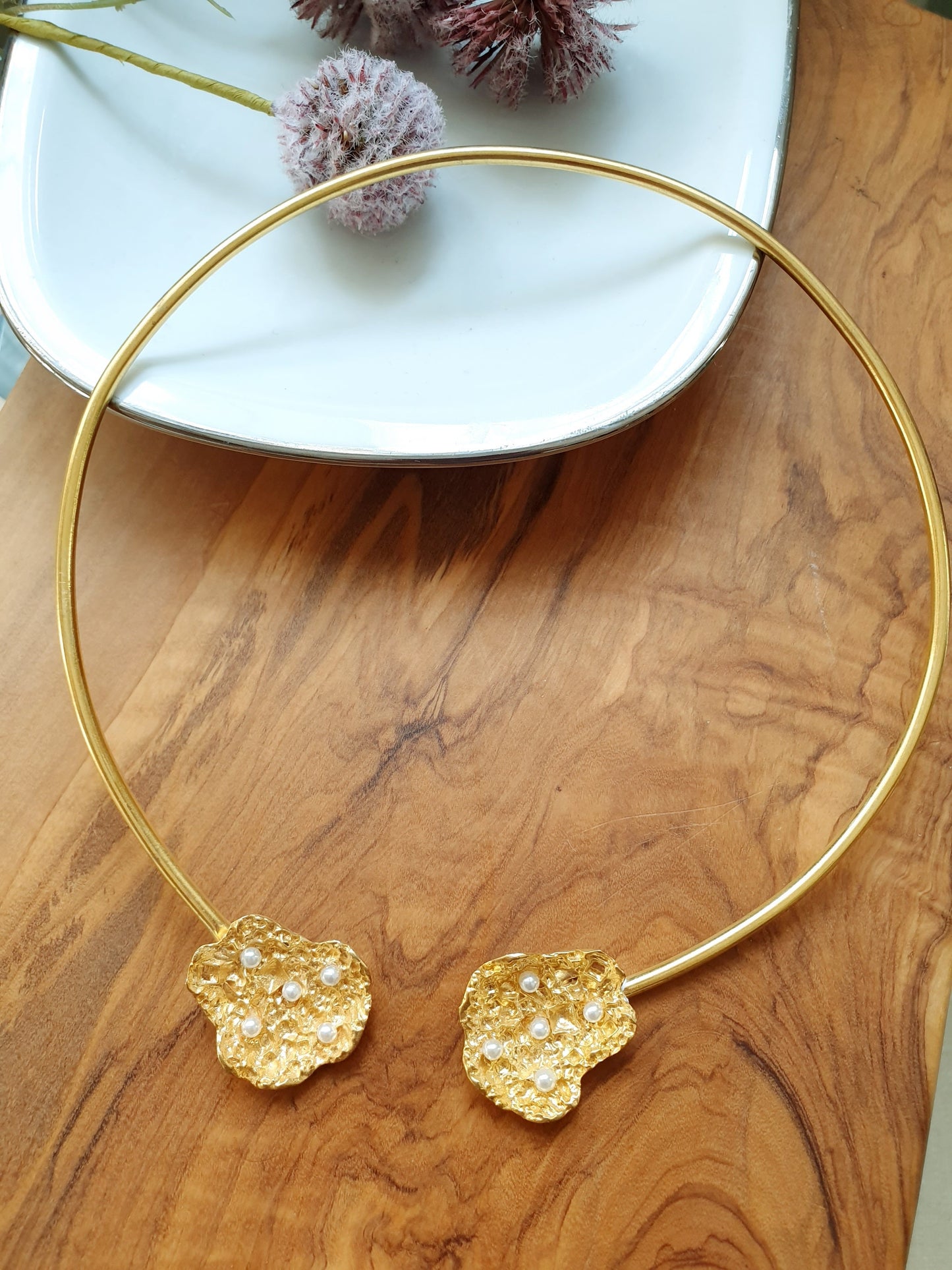 Halsband aus Messing mit Motiven und Perlen.