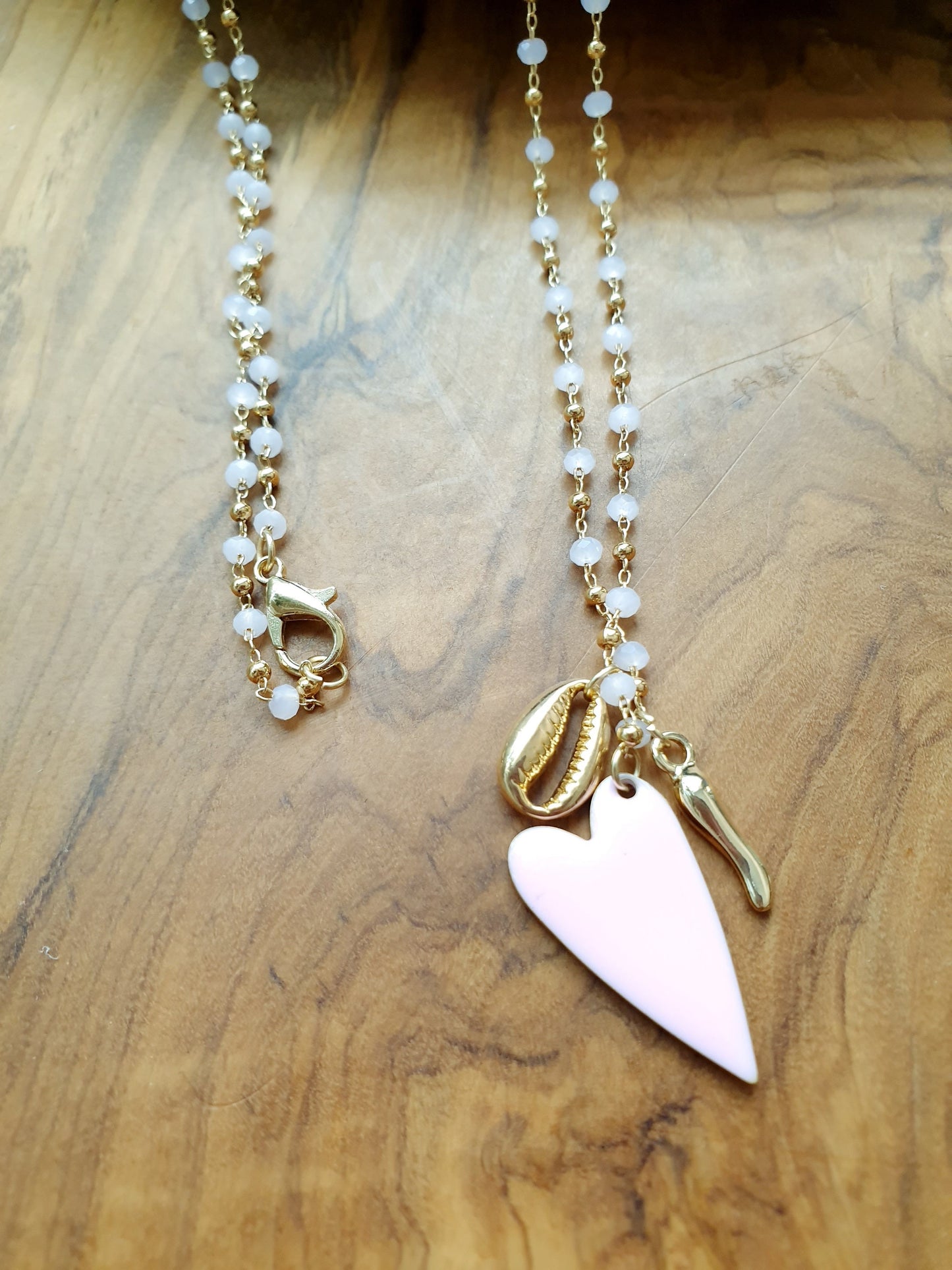 Lunga collana con perline, cuore, conchiglia, cornetto.