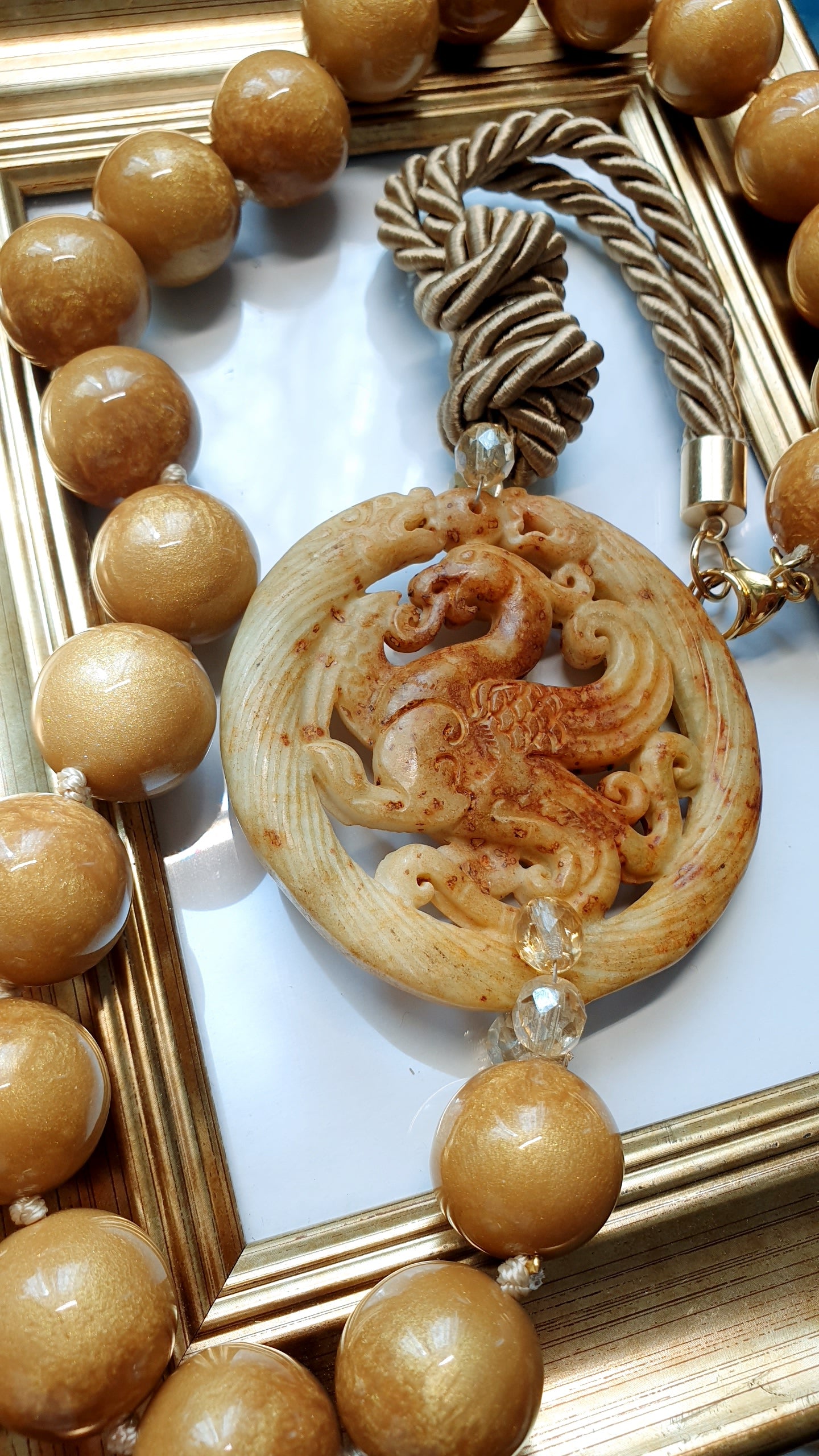 Lunga collana con sfere in resina, giada intagliata e cristalli miele