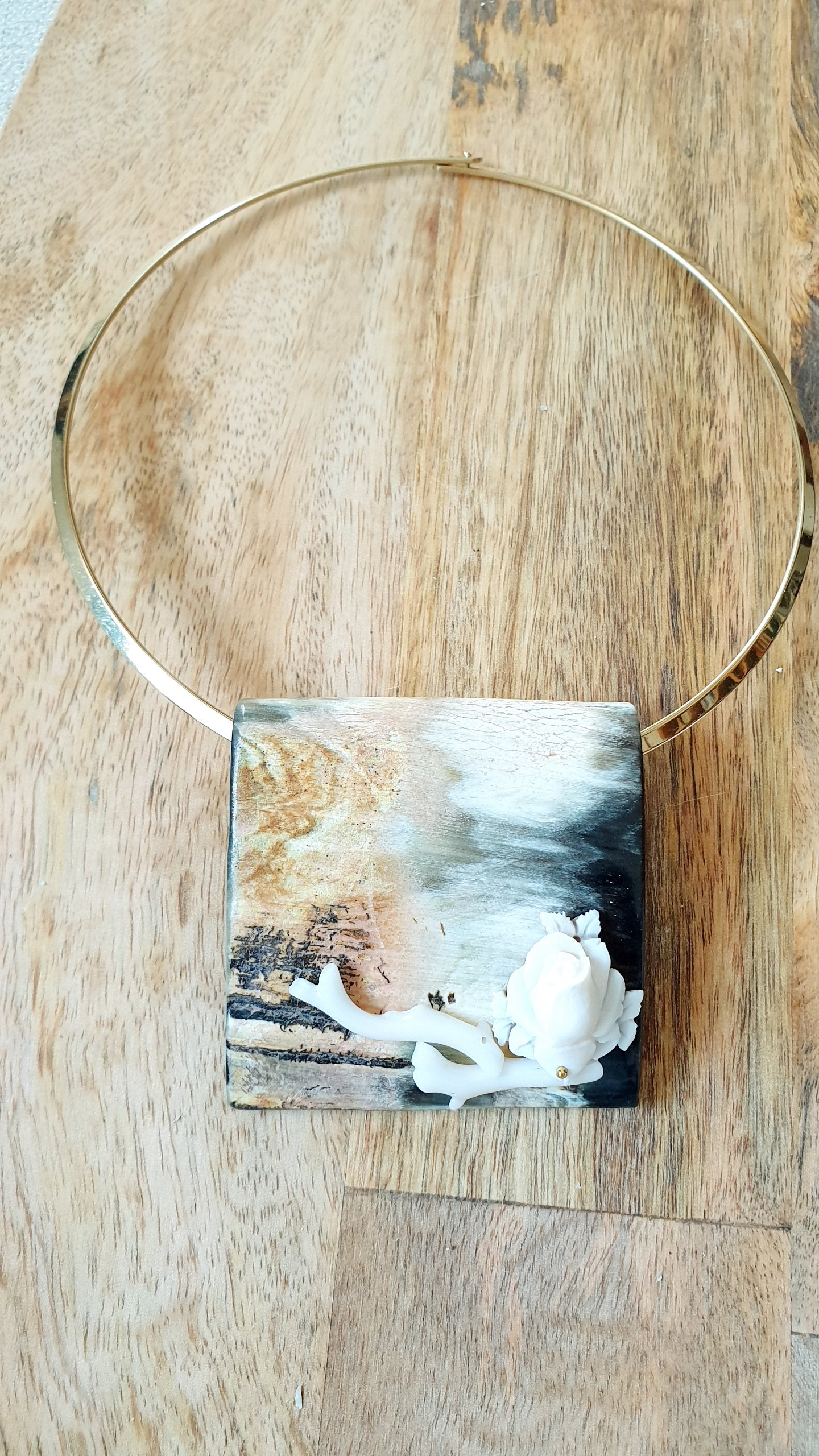 Particolare girocollo in acciaio con corno, cammeo, corallo bianco