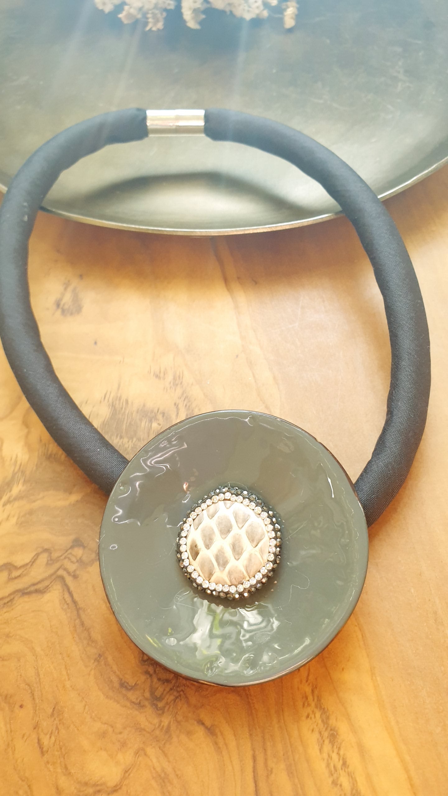 Girocollo in seta con disco laccato grigio, resina e marcassite.