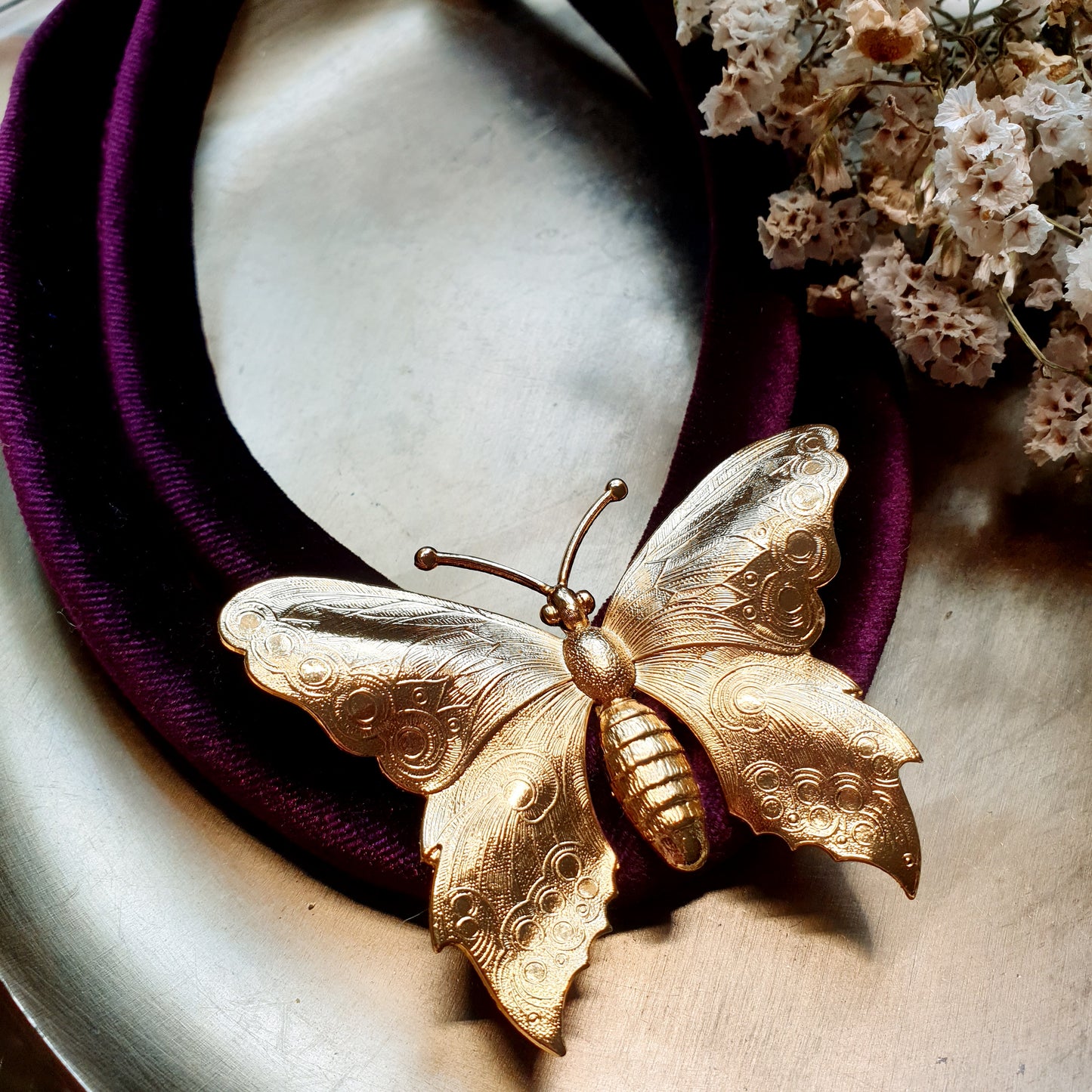 Collana in velluto con farfalla placcata oro.