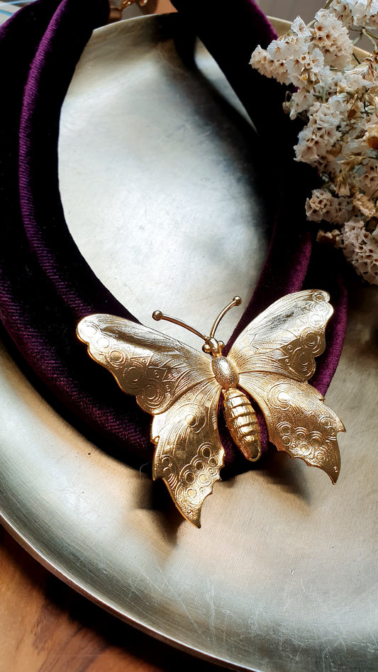 Collana in velluto con farfalla placcata oro.