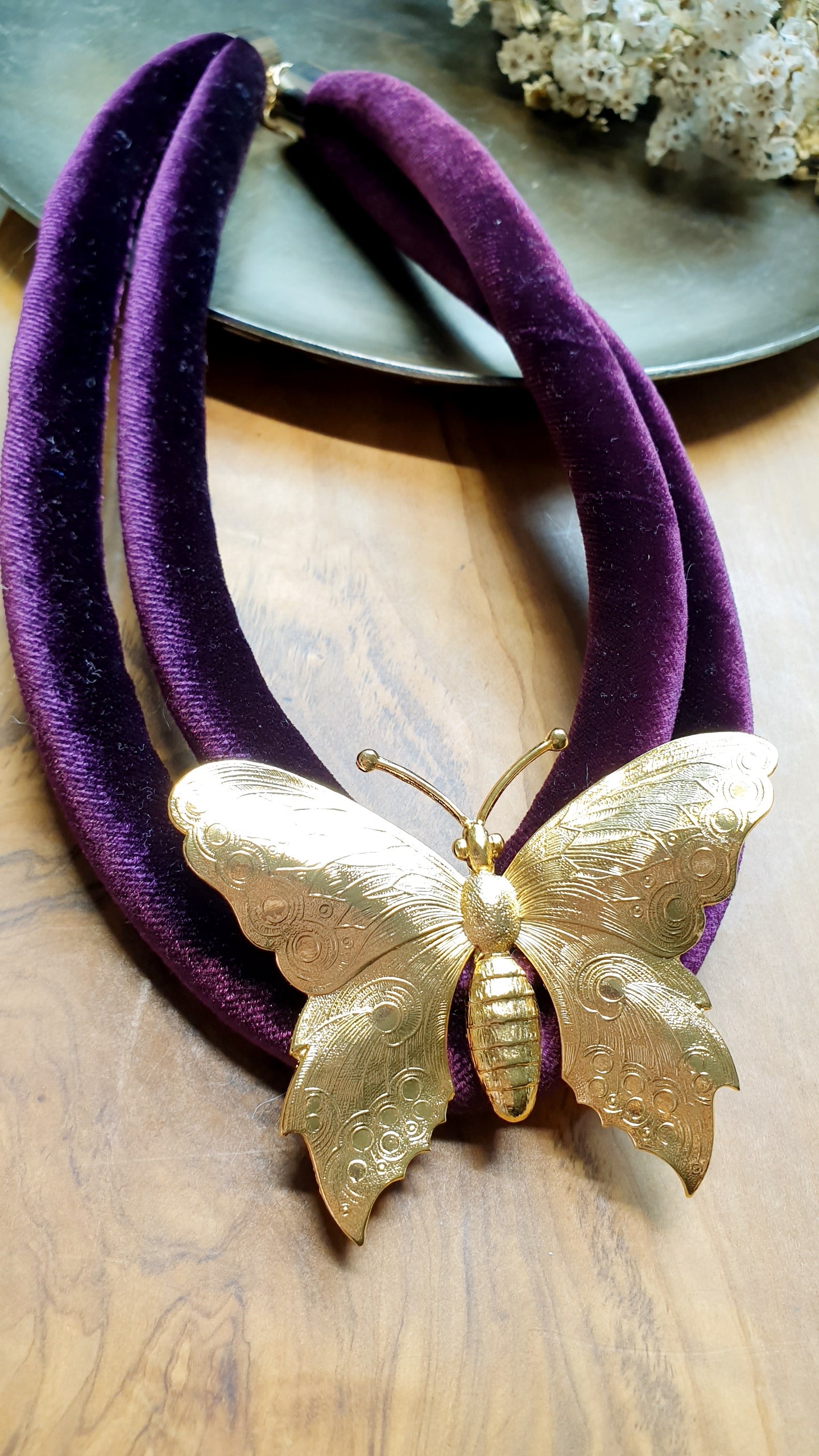Collana in velluto con farfalla placcata oro.