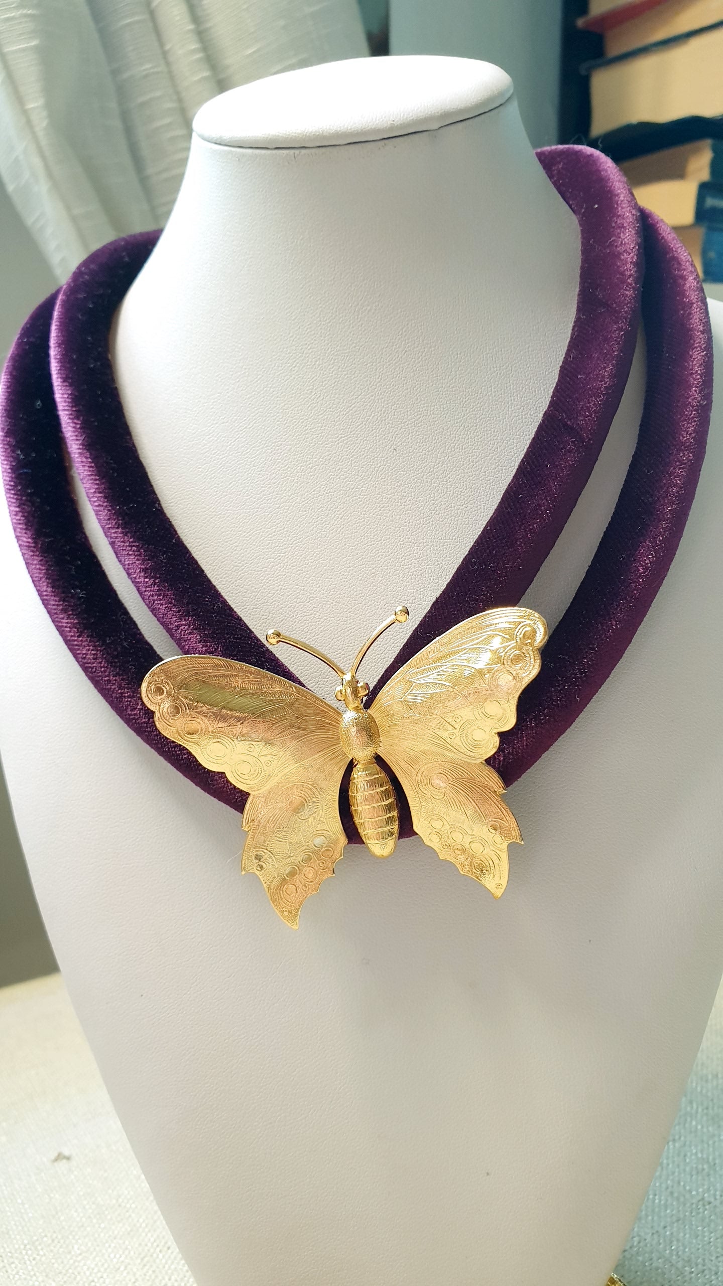 Collana in velluto con farfalla placcata oro.