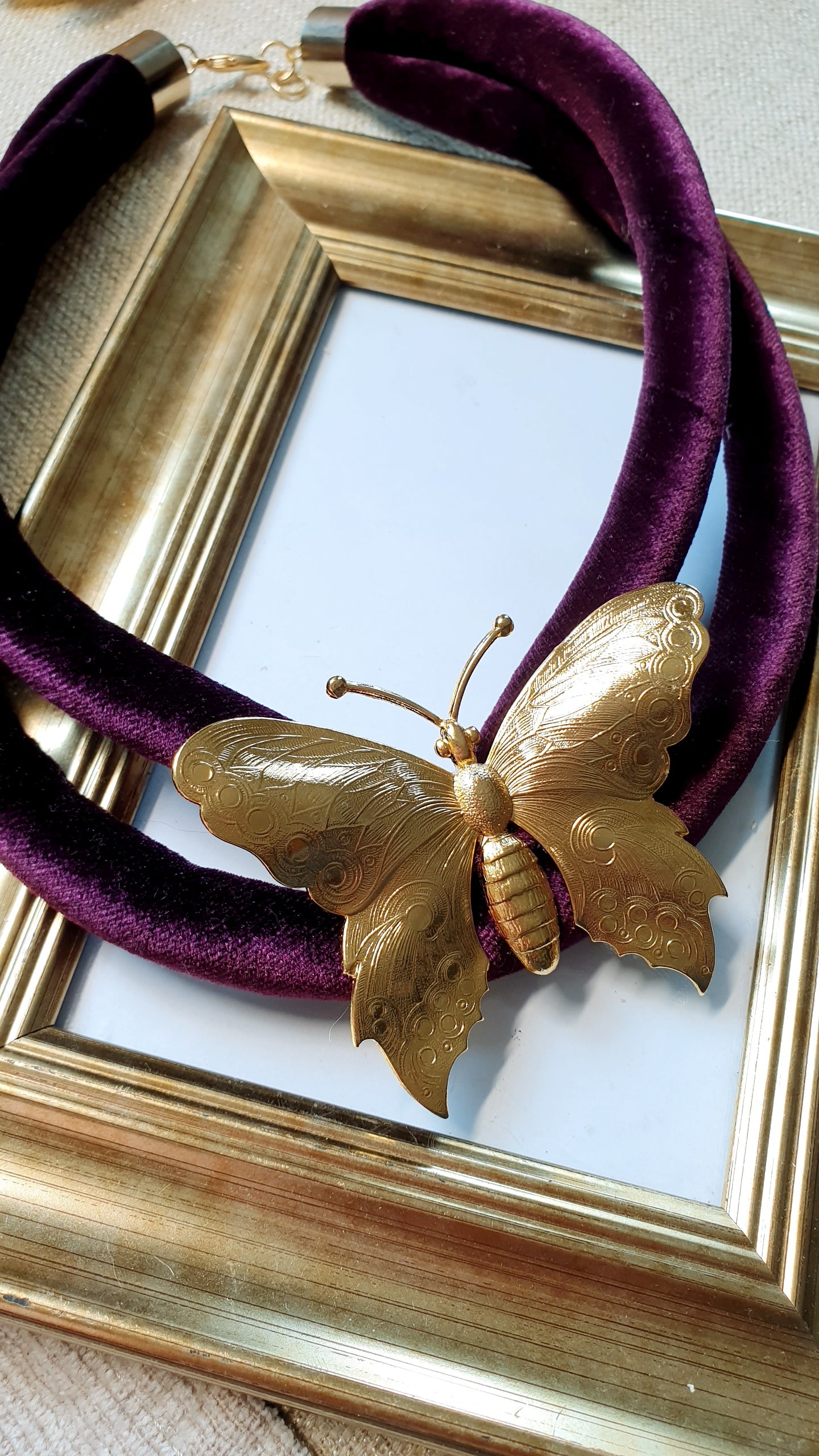 Collana in velluto con farfalla placcata oro.