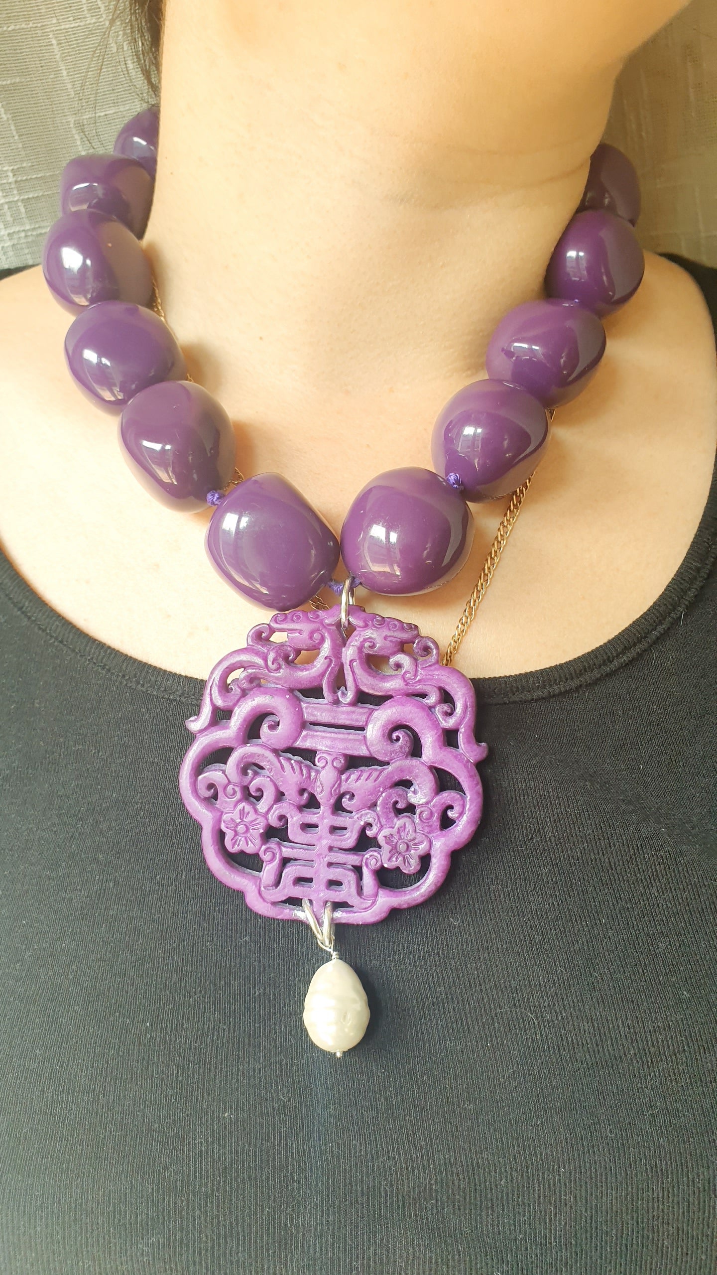 Collana in resina con giada intagliata e perla.