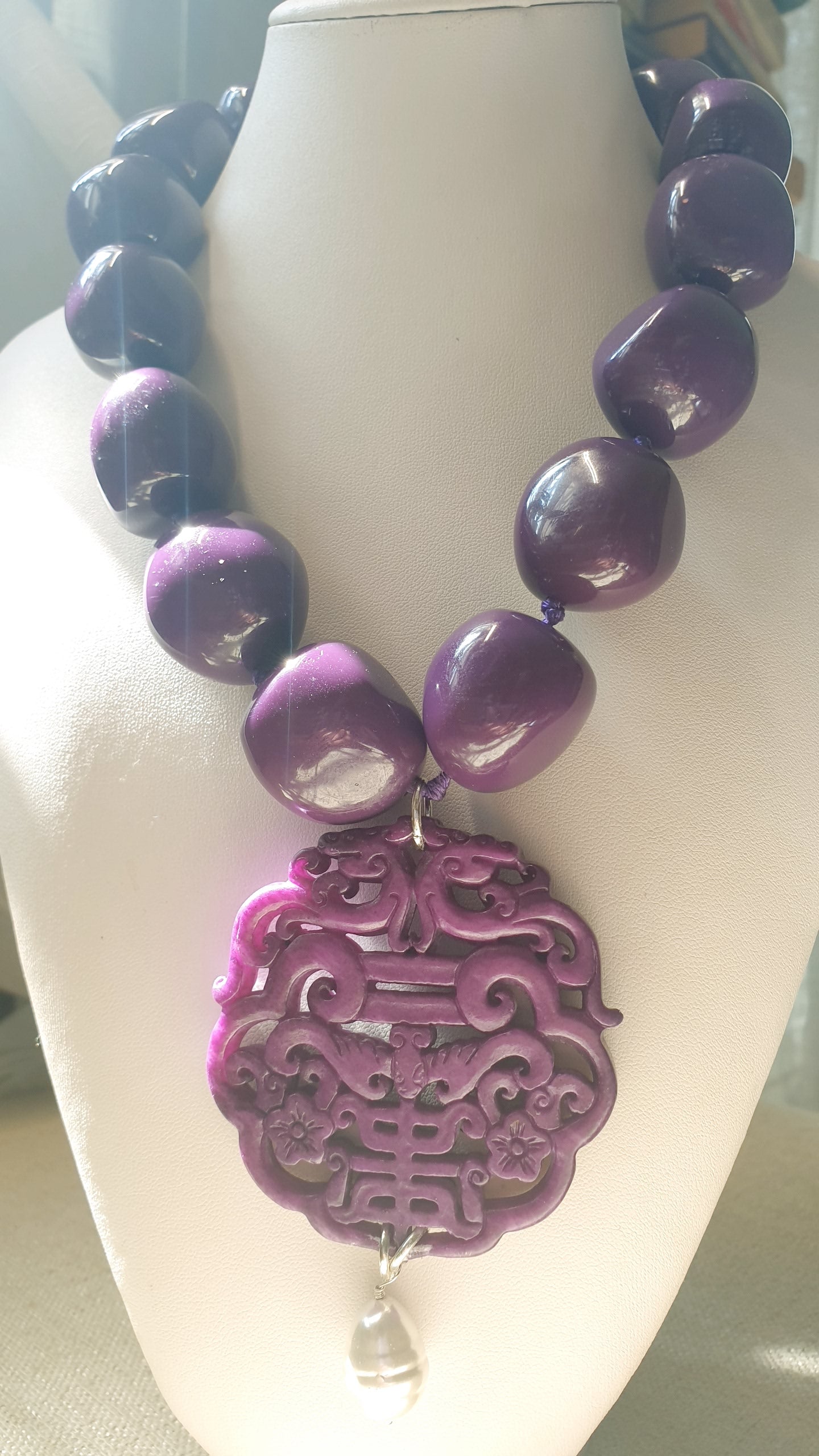 Collana in resina con giada intagliata e perla.
