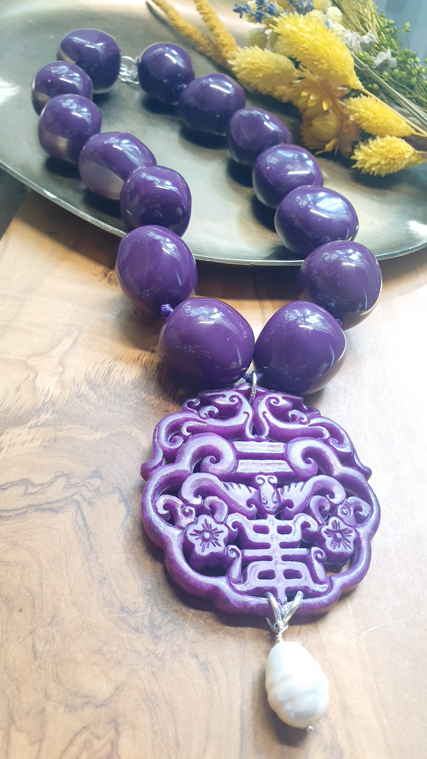 Collana in resina con giada intagliata e perla.