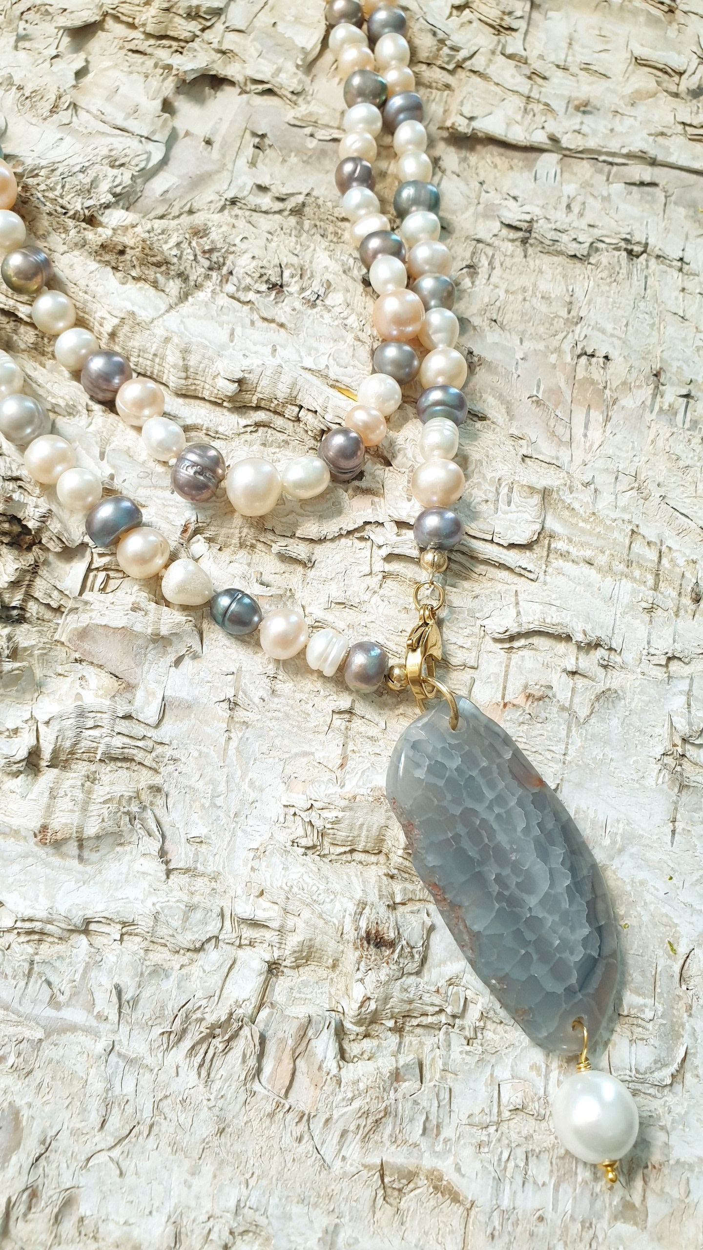 Lunga collana di perle di fiume con ciondolo di agata e perla.