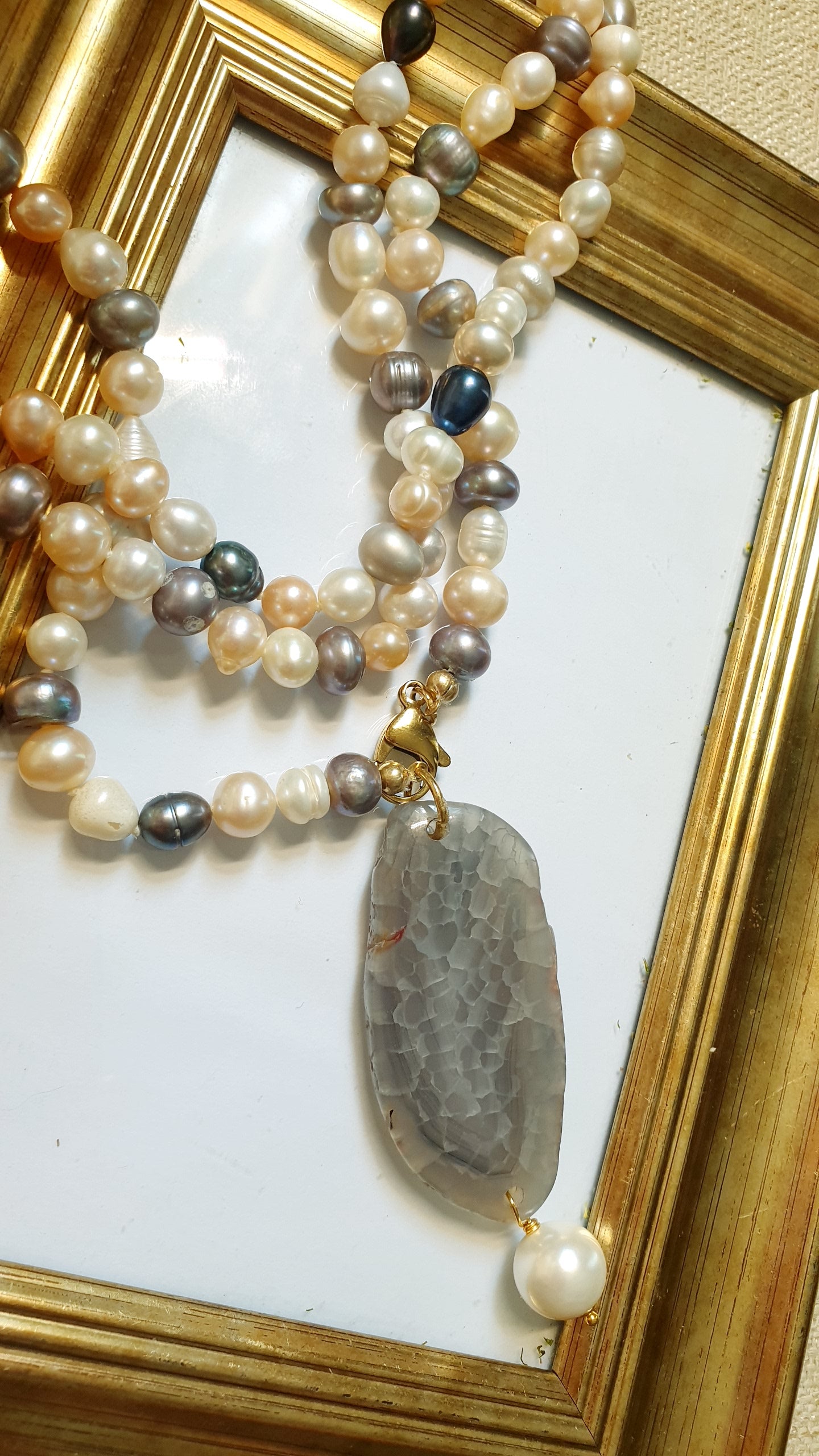 Lunga collana di perle di fiume con ciondolo di agata e perla.