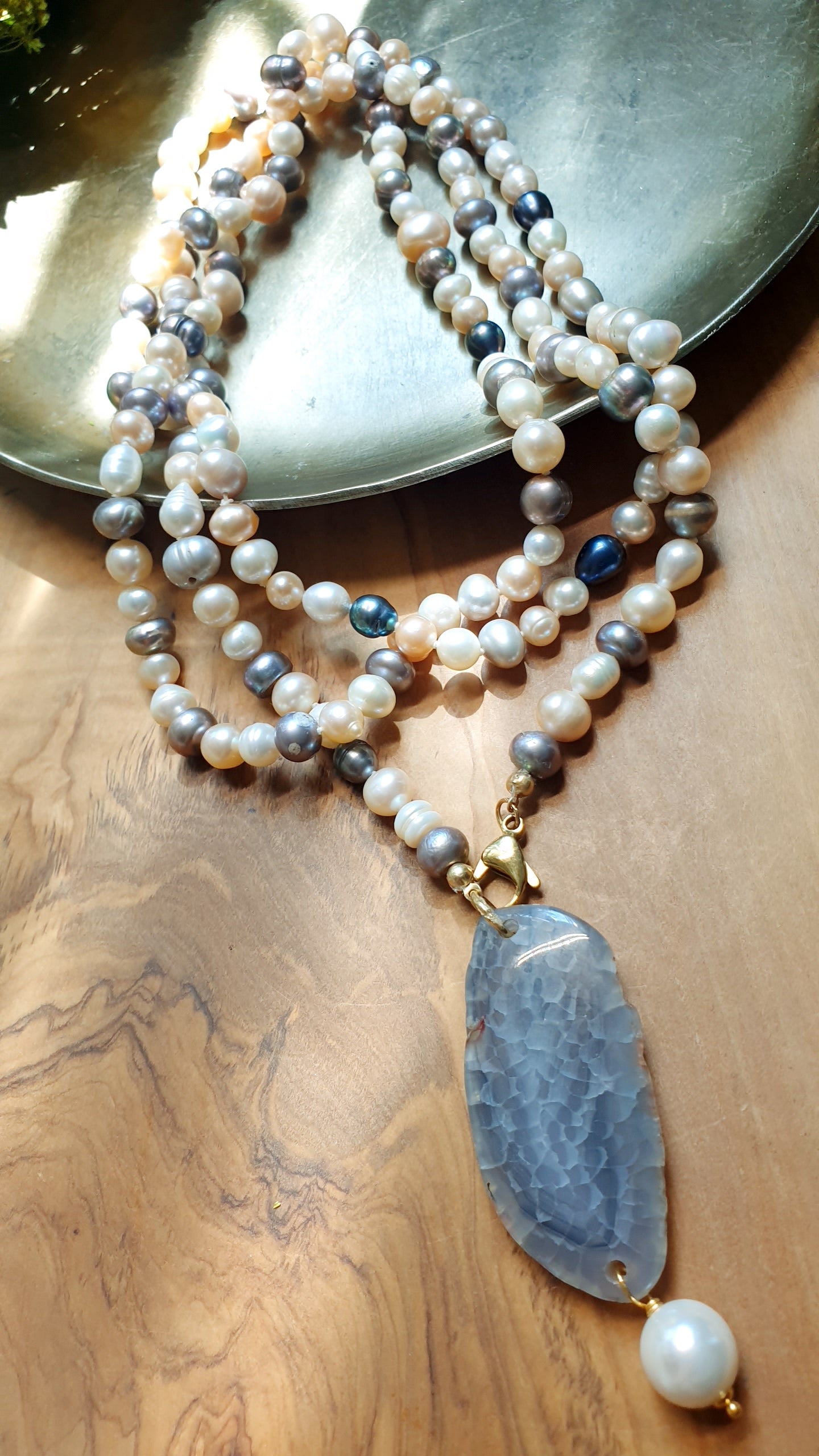 Lunga collana di perle di fiume con ciondolo di agata e perla.