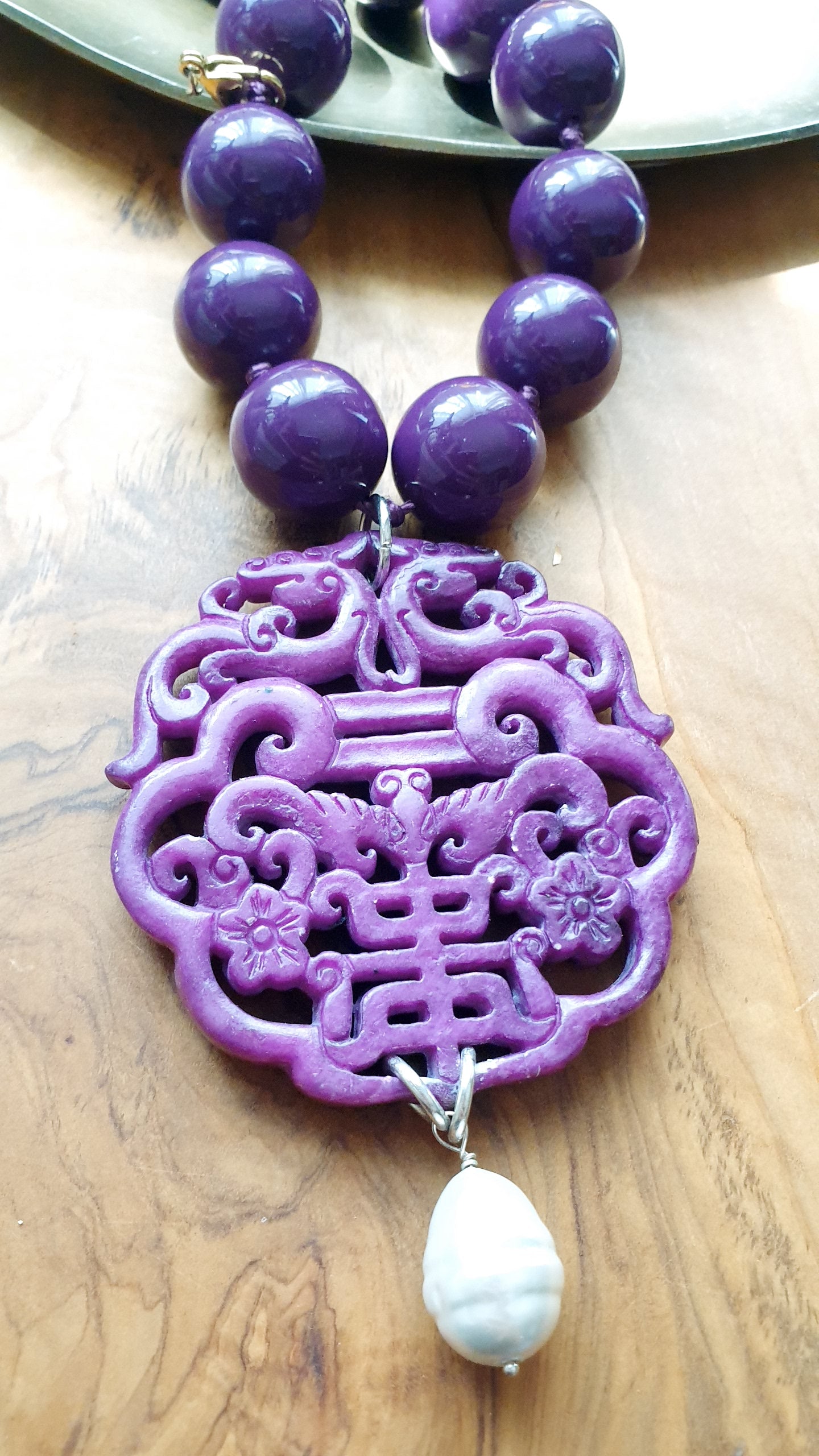Collana in resina con giada intagliata e perla.
