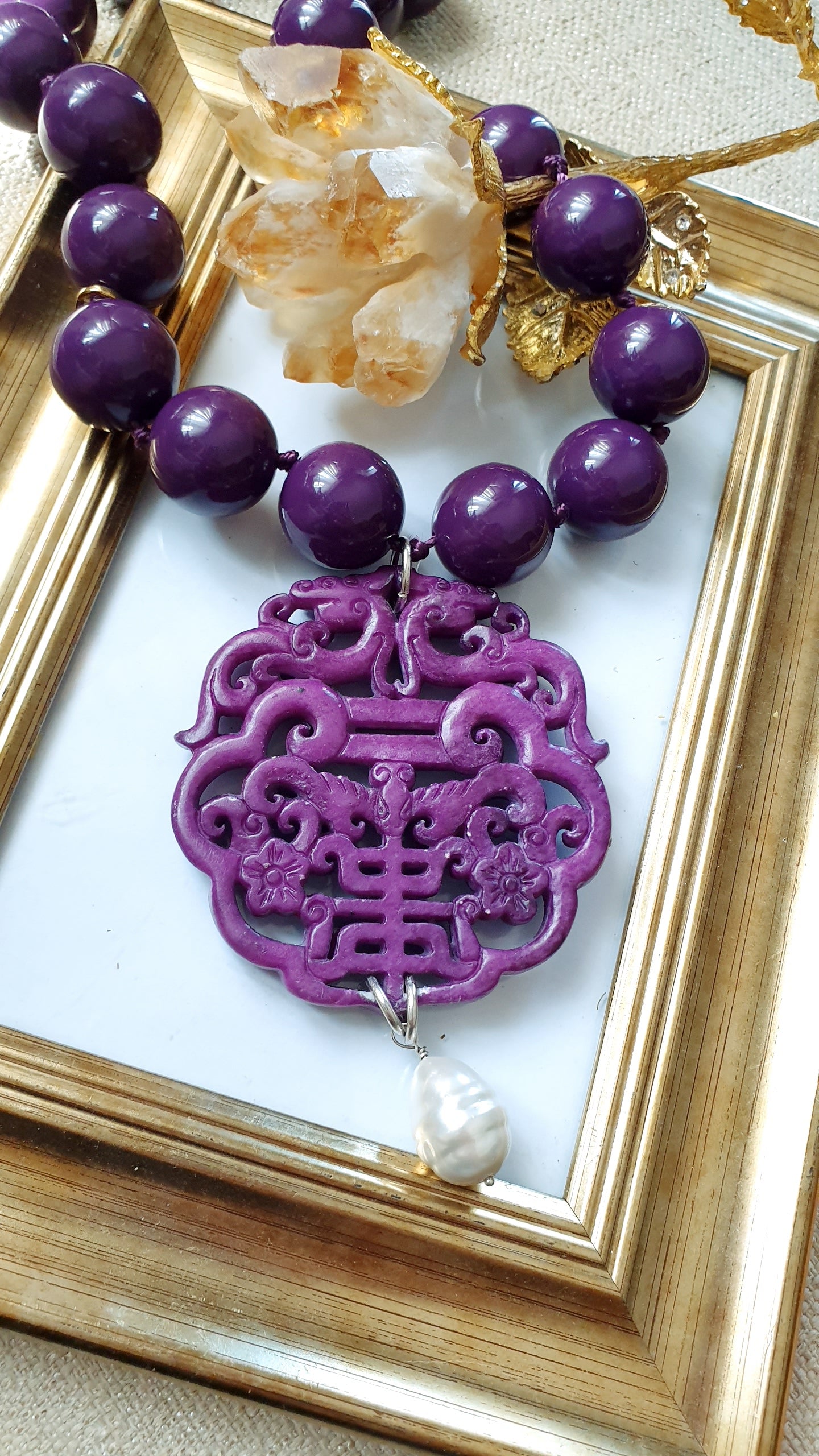 Collana in resina con giada intagliata e perla.