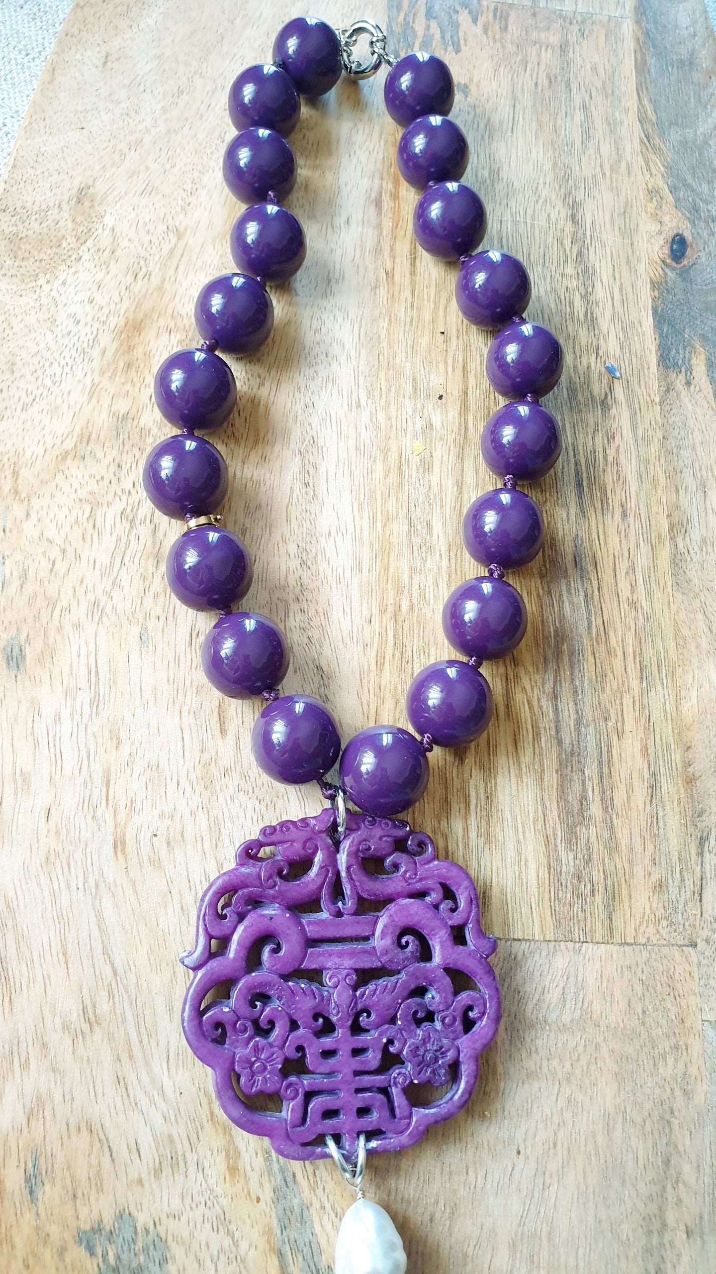 Collana in resina con giada intagliata e perla.