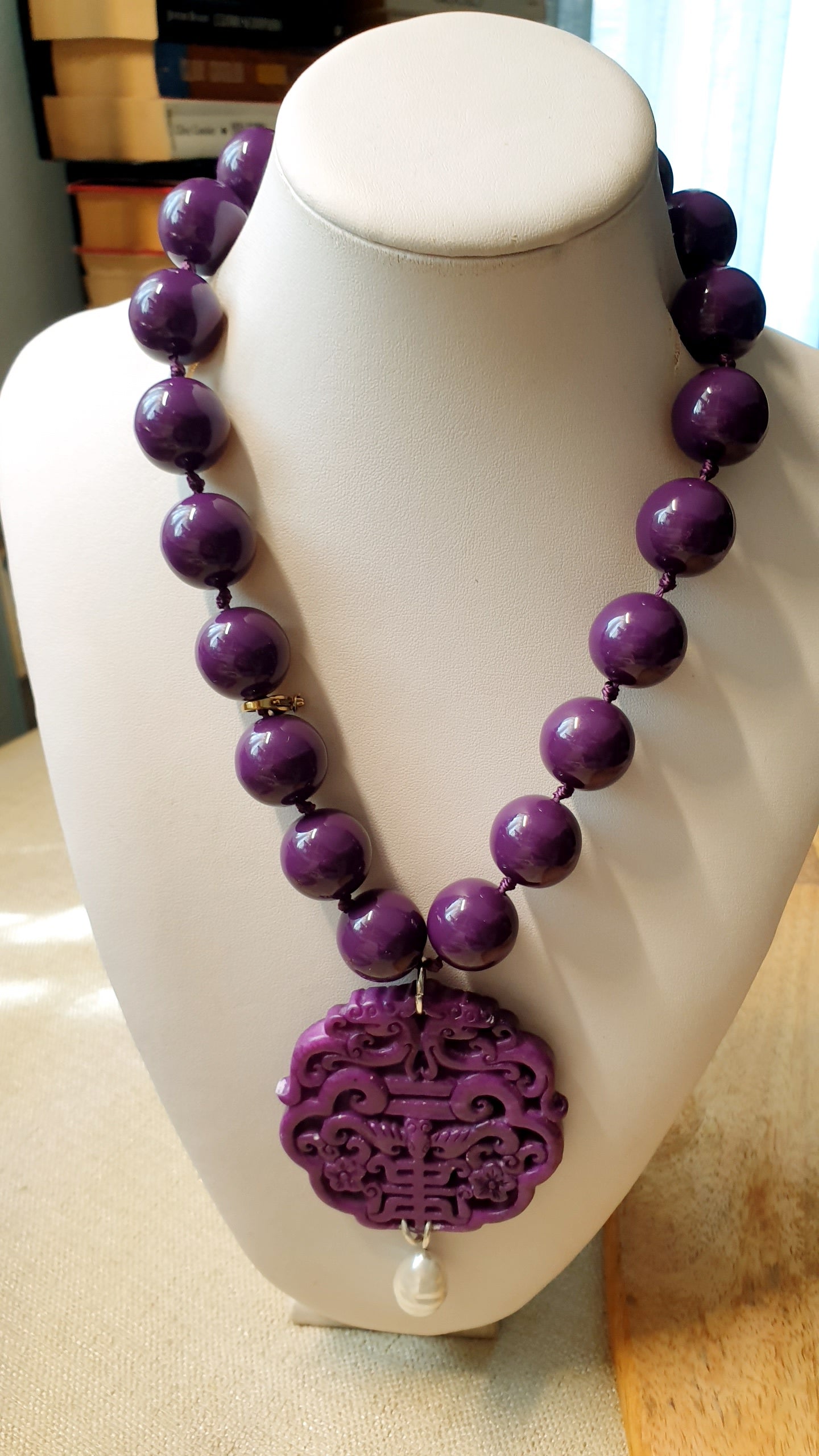 Collana in resina con giada intagliata e perla.