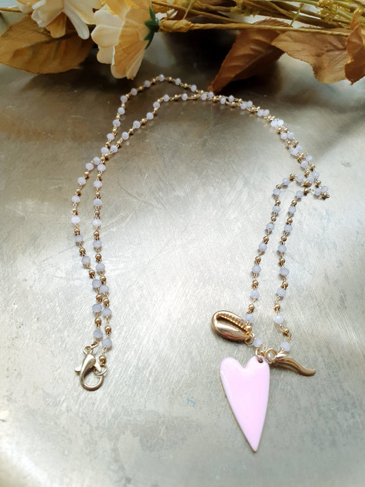 Lunga collana con perline, cuore, conchiglia, cornetto.